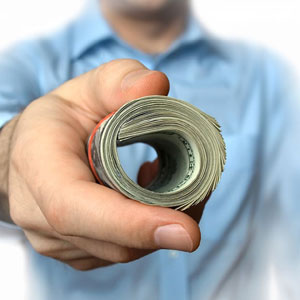Business owner holding a roll of cash